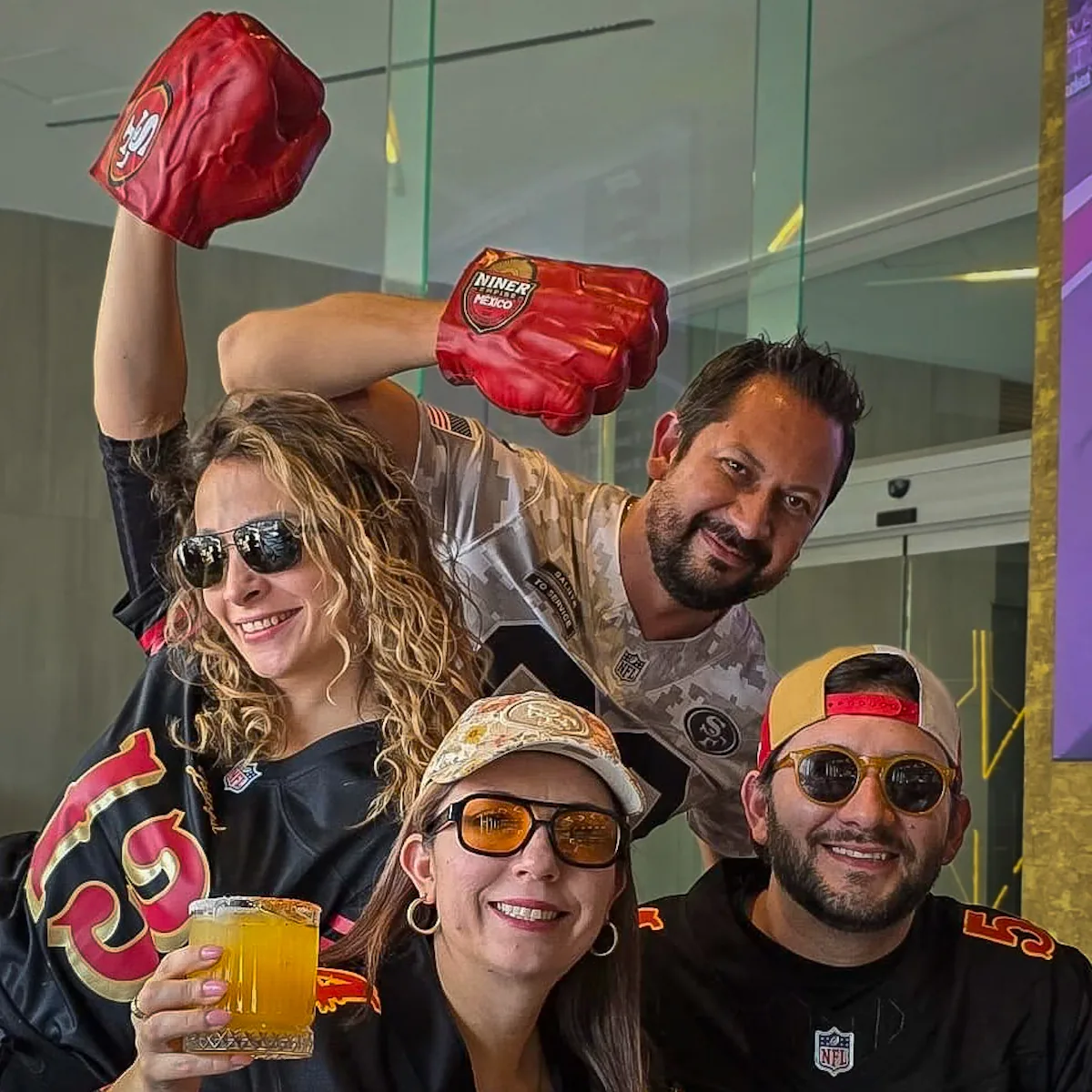 Cuatro miembros en una selfie con puños de hule de Niner Empire México en alto